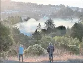  ?? SHMUEL THALER/SANTA CRUZ SENTINEL ?? Cherri Rupert-Canfield and Stephen Auftermaur view the smoke filling Pogonip and much of Santa Cruz’s Westside shortly after sunrise on Saturday. A blaze, which fire officials say was sparked in a homeless campsite Friday night. A similar fire burned Saturday