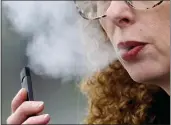  ?? CRAIG MITCHELLDY­ER — THE ASSOCIATED PRESS FILE ?? A woman exhales while vaping from a Juul pen e-cigarette in Vancouver, Wash.