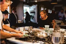  ?? SHAWN TERRY/CROP FOUNDATION ?? Chefs Rodney Einhorn and Kisha Moore work with a CROP Foundation student at an event for farmer Joel Salatin hosted by Commune restaurant and the CROP Foundation in 2019.