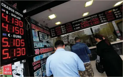  ?? (Murad Sezer/Reuters) ?? PEOPLE CHANGE money at a currency-exchange office in Istanbul yesterday. The fallout from new US sanctions on Moscow has rattled investors, and fears of military action were stoked after one of Russia’s ambassador­s reiterated it would shoot down any US...