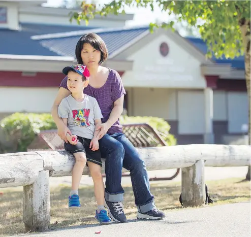  ?? ARLEN REDEKOP ?? Sunhee Gooding and her son Caeden, 5, sit in front of Walnut Road elementary in Surrey. Caeden has autism and the school board has only offered him a shared support worker, something his mother is against.