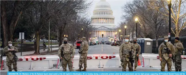  ?? —AFP ?? WASHINGTON, DC: Members of the US National Guard stand watch at the US Capitol in Washington, DC on Sunday during a nationwide protest called by anti-government and far-right groups supporting US President Donald Trump and his claim of electoral fraud in the November 3 presidenti­al election.
