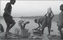  ?? TYLER HICKS / THE NEW YORK TIMES ?? Refugees gather water at a reservoir at the edge of a refugee camp in Bentiu, South Sudan. An annual report from the United Nations refugee agency said 68.5 million people worldwide were classified in 2017 as having been forcibly displaced because of...