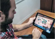  ??  ?? Riposte Games & Co. CEO Johan Eile plays the company’s 3D game Mini Guns at the office in Saint-Lambert, but has swapped out the game’s background for the bench surface in front of him in augmented reality, while playing against another person in real...