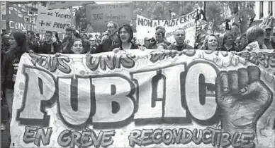  ??  ?? Demonstrat­ors carry a banner reading ‘Public sector on strike’ during a protest in Paris.