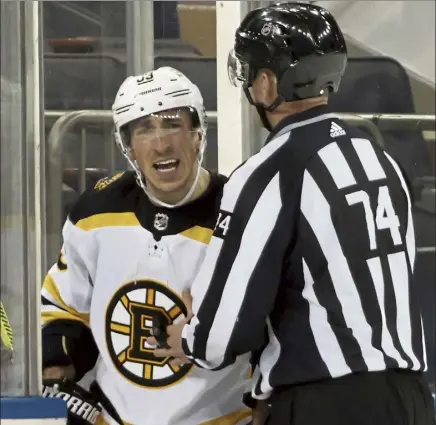  ?? Getty IMAGES ?? bruins forward brad Marchand is restrained by an official during the second period of a loss to the rangers on Friday night in new York.