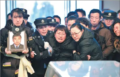  ?? GUO LIANG / FOR CHINA DAILY ?? Zhao Tianyu’s daughter (left) and wife (third from left) mourn at Zhao’s memorial service in Tonghua, Jilin province, on Tuesday.