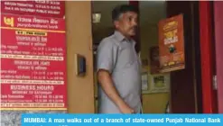  ?? —AFP ?? MUMBAI: A man walks out of a branch of state-owned Punjab National Bank yesterday.