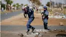  ??  ?? Servicios de Policía de Sudáfrica (SAPS) fuera del saqueado centro comercial Lotsoho Mall, en Katlehong, al este de Johannesbu­rgo.