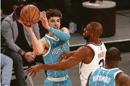  ?? MARK J. REBILAS/USA TODAY SPORTS ?? Lamelo Ball scored 20 points and dished out eight assists to help Charlotte beat Chris Paul and Phoenix 124-121 Wednesday night.