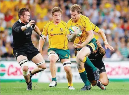  ??  ?? No way, mate: All Blacks captain Richie McCaw moves in to stop Australia’s Pat McCabe in the Bledisloe Cup Test on Saturday. The match ended 18-18.