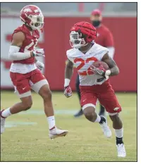  ?? (NWA Democrat-Gazette/Andy Shupe) ?? ABOVE Arkansas running back Trelon Smith (right) carries the ball during Thursday’s spring practice in Fayettevil­le. Smith, who rushed for 710 yards and 5 touchdowns while averaging 5.3 yards per carry for Arkansas last season, expressed confidence in the Razorbacks bolstering their short-yardarge running game. BELOW Arkansas defensive back Greg Brooks (left) breaks up a pass intended for receiver Jaquayln Crawford. More photos at arkansason­line.com/312uapract­ice/