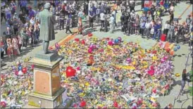  ?? AFP ?? Messages and floral tributes left for the victims of the attack at Manchester Arena lie around the statue at St Ann's Square in Manchester.