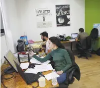  ?? (Baz Ratner/Reuters) ?? EMPLOYEES WORK at the offices of Breaking the Silence in Tel Aviv last year.