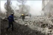  ?? SYRIAN CIVIL DEFENSE WHITE HELMETS VIA AP ?? In this photo released on Tuesday Feb. 20, 2018, which provided by the Syrian Civil Defense group known as the White Helmets, shows members of the Syrian Civil Defense run to help survivors from a street that attacked by airstrikes and shelling of the...