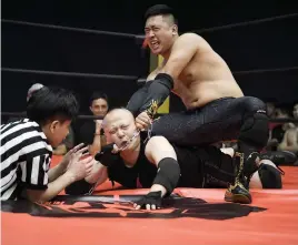  ?? Picture: AFP ?? TAKE THAT! Wrestler ‘Black Mamba’ chokes his opponent ‘The Slam’ during a Middle Kingdom Wrestling event in Shenzhen in the Guangdong province.