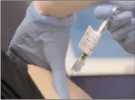  ?? The Associated Press ?? A nurse injects a volunteer with a vaccine as part of an Imperial College trial at a clinic in London, Wednesday.