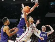  ?? Garrett Fisbeck / Associated Press ?? Surrounded by TCU defenders, Oklahoma’s Trae Young nonetheles­s makes a concerted effort to score two of his 43 points Saturday.