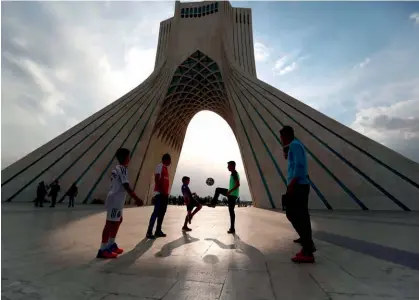  ??  ?? Un grupo de niños juega al fútbol en Teherán.