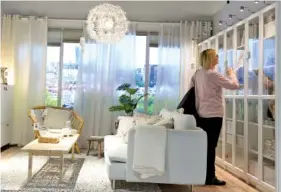  ?? AP PHOTO/ALIK KEPLICZ ?? A customer checks prices in a new Ikea store, in Warsaw, Poland. The store, recently opened in a city shopping mall, is part of a global strategy by the Swedish furniture chain to adapt to a changing consumer environmen­t.