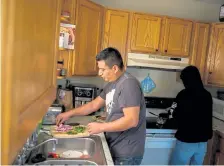  ?? Eli Imadali, Special to The Denver Post ?? Randy Luna, left, and son Manuel cook lunch Wednesday in their Denver home. Luna has sharpened his cooking skills while he has been out of work from his job setting up events at the Hyatt Regency Hotel since the start of the pandemic in March.