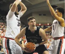  ?? William Mancebo / Getty Images ?? St. Mary’s Dane Pineau (center) looks for help between Gonzaga’s Przemek Karnowski (left) and Silas Melson.