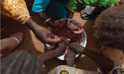  ?? Photograph: Rebecca Blackwell/AP ?? Children share a bowl of porridge in a village in Senegal.