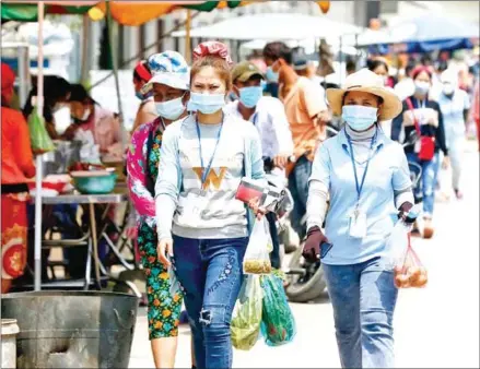  ?? HENG CHIVOAN ?? Factory workers out for lunch in Chaom Chao commune in Phnom Penh’s Por Sen Chey district.