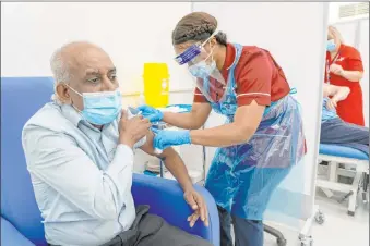  ?? Dan Charity The Associated Press ?? Care home worker Pillay Jagambrun, 61, receives the Pfizer-biontech COVID-19 vaccine Tuesday, the first day of the largest immunizati­on program in Britain’s history.