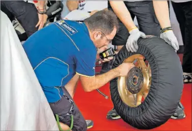  ?? ?? Un técnico de Michelin comprueba el neumático durante unas pruebas en Sepang.