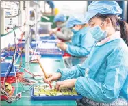  ?? CHEN SIHAN ?? Workers examine inductors produced at a poverty alleviatio­n workshop in Hunan Province.