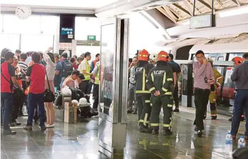  ?? AGENCY PIX ?? Civil defence force personnel at the scene of a train collision in Singapore yesterday.