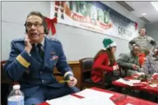 ?? BRENNAN LINSLEY — THE ASSOCIATED PRESS FILE ?? In this file photo, Canadian Brig. Gen. Guy Hamel, NORAD and USNORTHCOM Deputy Director of Policy, Strategy, and Plans, joins other volunteers taking phone calls from children around the world asking where Santa is and when he will deliver presents to...