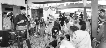  ??  ?? Haris entertaini­ng the family members and guests with a Hari Raya song.