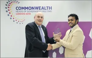  ??  ?? Elvis Kumar receiving his award from the Commonweal­th Secretaria­t Chief Operating Officer – Nigel Morland in London