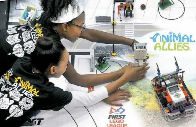  ?? Lake Fong/Post-Gazette ?? Mahogany Henderson, top, and Eloise Simon, both 10 and members of YSM Robots, practice prior to the Western Pennsylvan­ia First Lego League grand championsh­ip tournament Saturday at La Roche College.