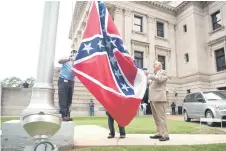  ?? — AFP photos ?? The state flag is raised for the flag retirement ceremony at the Mississipp­i State Capitol building in Jackson, Mississipp­i.