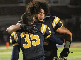  ?? DAVID JABLONSKI / STAFF ?? Springfiel­d’s Isaiah Gibson and Jeff Tolliver (35) embrace Friday night after the Wildcats defeated Wayne in overtime to clinch a playoff berth.