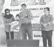  ??  ?? DAYANG MADINAH menyampaik­an hadiah kepada para pemenang pada Jualan Garaj 2017 di Kuching.