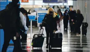  ?? NAM Y. HUH
THE ASSOCIATED PRESS ?? A traveler wears a mask as she walks through Terminal 3 at O’Hare Internatio­nal Airport in Chicago on Sunday. The Transporta­tion Security Administra­tion said nearly 1.2 million people went through U.S. airports on Sunday, the highest number since the coronaviru­s pandemic gripped the country back in March.