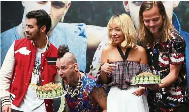  ?? — IBRAHIM MOHTAR/The Star ?? (l-r) Jonas, Whittle, Lee and Lawless of DNCE, were presented with two nasi lemak cakes during the press conference.