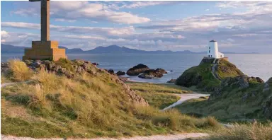  ?? ?? Haunting drama: A lighthouse on Anglesey looks out on the mountains of Snowdonia