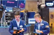  ?? DAVID L. NEMEC/NEW YORK STOCK EXCHANGE ?? New York Stock Exchange traders Orel Partush, left, and Robert Charmak work on the floor Friday. Stocks on Wall Street fell sharply Friday after getting hammered by data showing inflation is getting worse, not better.