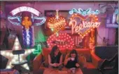  ?? NIKLAS HALLEN’N / AGENCE FRANCE-PRESSE ?? Patrons relax at God’s Own Junkyard gallery, cafe and workshop in Walthamsto­w, East London, which offers a labyrinth of neon signs.