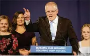  ?? RICK RYCROFT / AP ?? Australian Prime Minister Scott Morrison of the conservati­ve Liberal Party speaks to supporters today in Sydney flanked by his wife, Jenny, and daughters, Abbey (left) and Lily, after his center-left opponent conceded in the federal election.