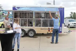  ?? Staff photo by Karl Richter ?? ■ The Texarkana Animal Care and Adoption Center’s new adoption trailer is opened to reveal dogs and cats inside, behind Plexiglas windows Tuesday at Arkansas Convention Center in Texarkana, Ark.