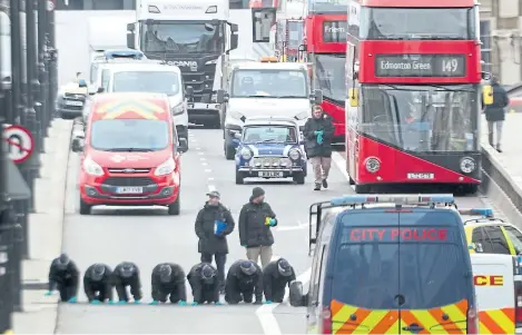  ?? Picture: PA. ?? Forensic officers carry out a search at a cordoned off area on London Bridge after Friday’s attack.