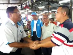  ??  ?? Dr Teo (left) shakes hands with hawkers at Emart Market.