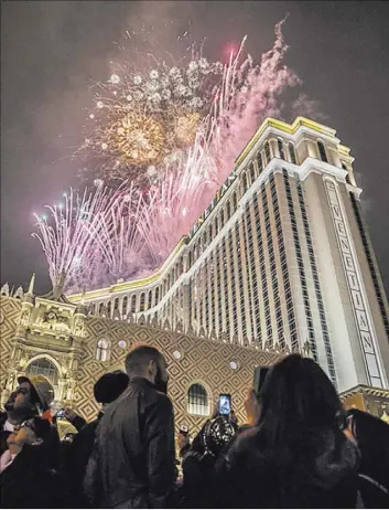  ?? Benjamin Hager Las Vegas Review-Journal ?? New Year’s Eve party-goers mingle and watch the fireworks outside The Venetian on the Strip to welcome in 2017.