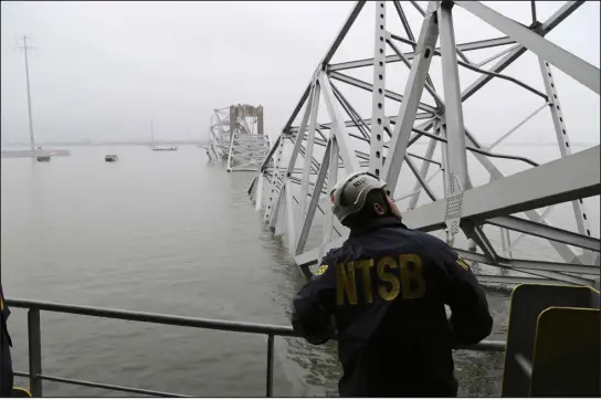  ?? PETER KNUDSON — NTSB VIA AP ?? A National Transporta­tion and Safety Board investigat­or, aboard the cargo vessel Dali, surveys the scene of the collapsed Francis Scott Key Bridge on Wednesday in Baltimore. Six constructi­on workers fixing potholes on the bridge are presumed dead in the collapse.